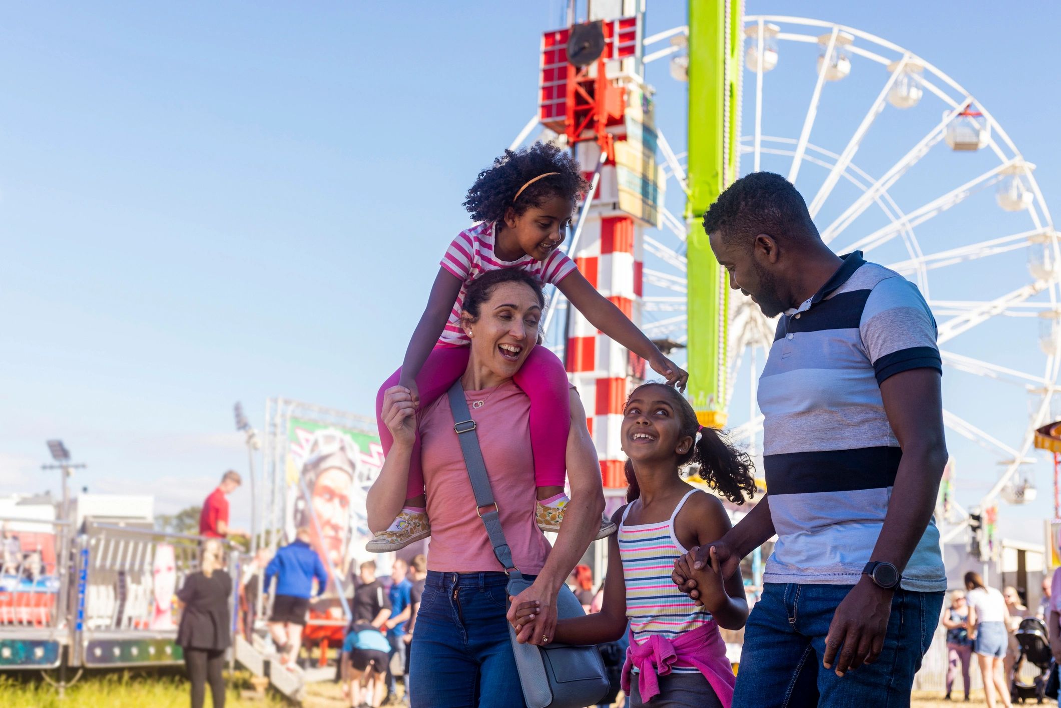 Smiling family walking through a fairground